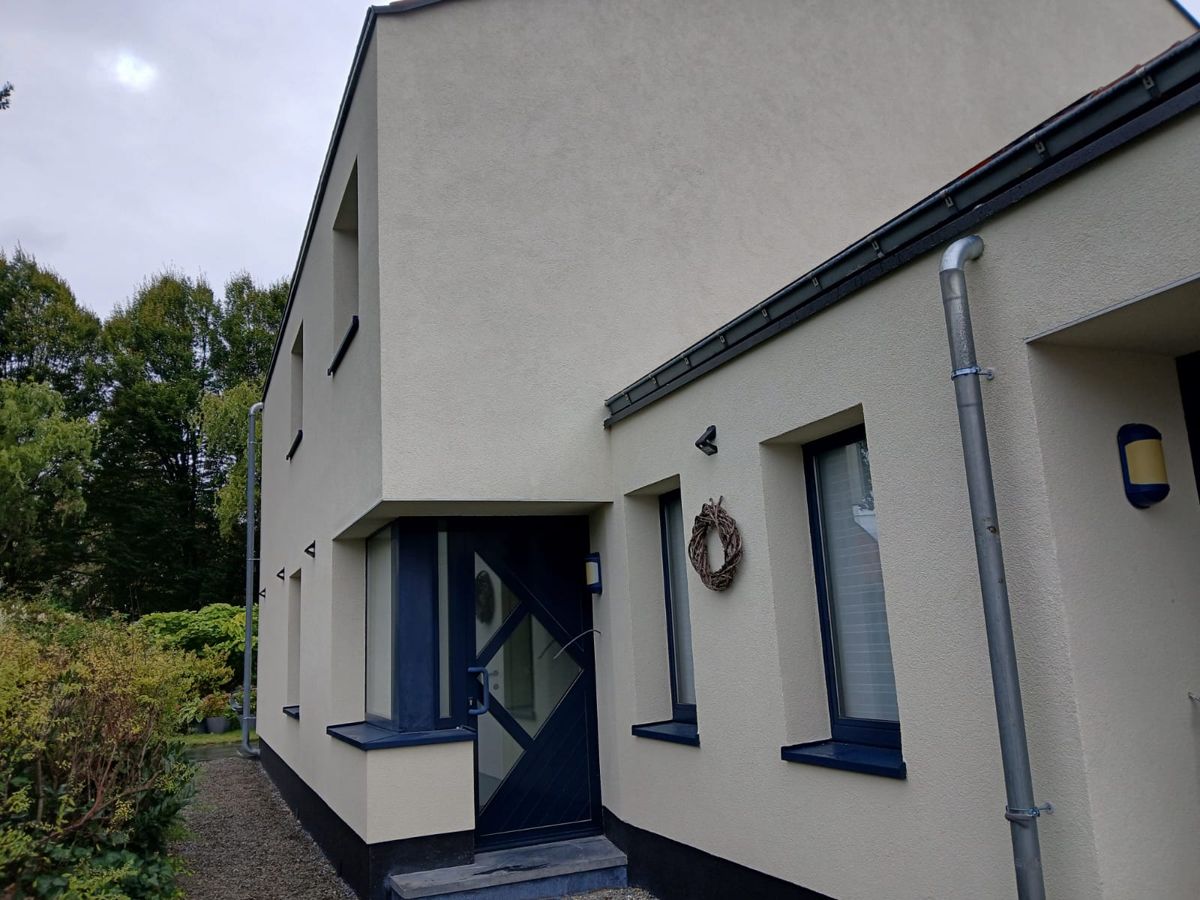 Woning met crème crepi en donkere raamlijsten